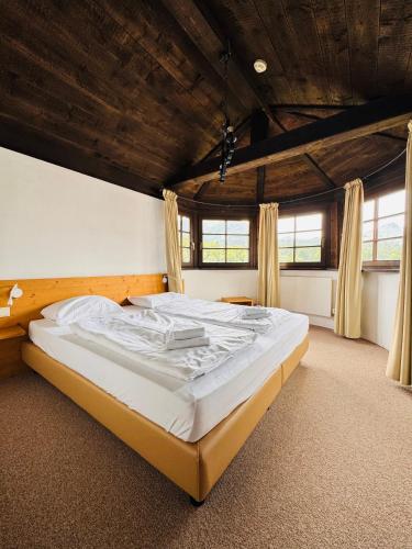 a large bed in a room with a wooden ceiling at Family Hotel Schloss Rosenegg in Fieberbrunn