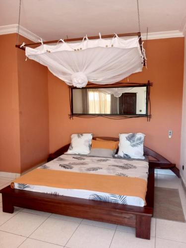 a bedroom with a bed with a canopy at Appart'hotel Les Capucins in Mahajanga