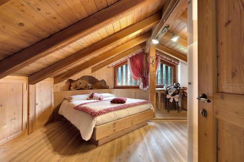 a bedroom with a bed in a wooden house at Bnb Erba Maga in Rabbi