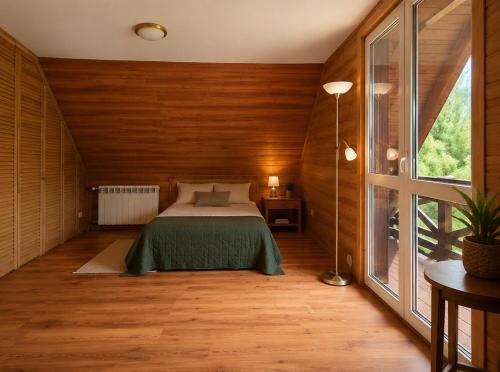 a bedroom with a bed and a large window at Jakubowo in Długi Bród
