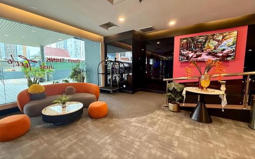 a lobby with a couch and chairs and a table at Apex by Bukit Bintang Hotel in Kuala Lumpur