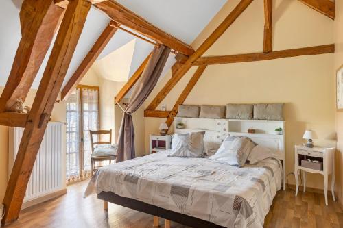 a bedroom with a large bed with wooden beams at Chambres D'hôtes 4 Saisons in Villefranche-Sur-Cher