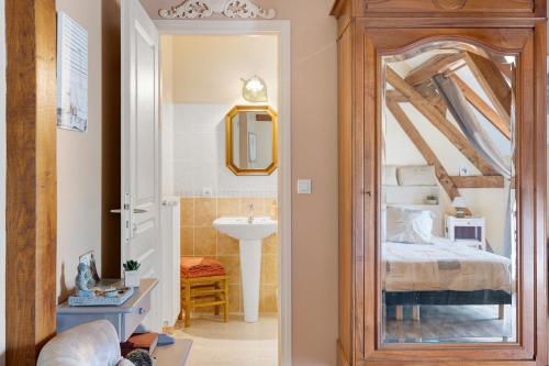 a bathroom with a bed and a sink and a mirror at Chambres D'hôtes 4 Saisons in Villefranche-Sur-Cher