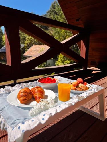 a breakfast table with croissants and fruit and orange juice at Jakubowo in Długi Bród