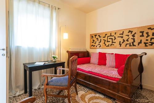 a living room with a red couch and a table at Villa Rosmarino in Camogli