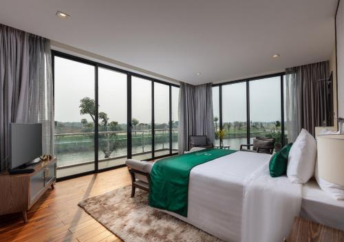 a bedroom with a large bed and large windows at DIC Star Villas Vinh Phuc in Vị Trù