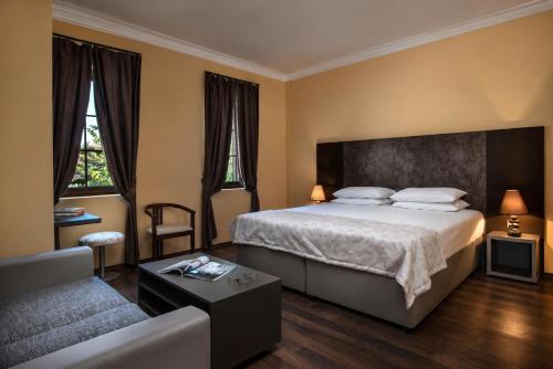 a hotel room with a bed and a couch at Effect Boutique Villa Azzura - Adults Only SELF CHECK-IN in Nesebar