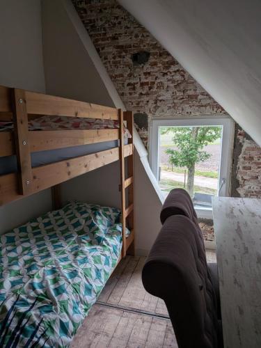 a bedroom with a bunk bed and a couch at BoerLangendijk in Rucphen