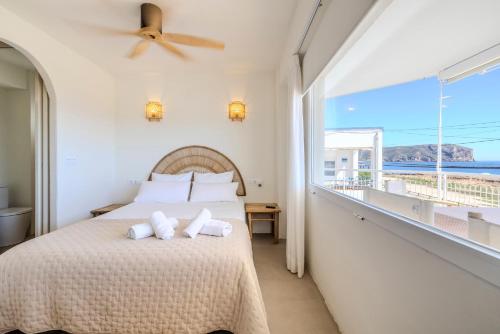 a bedroom with a bed and a balcony with the ocean at Apartment with sea view Javea in Jávea