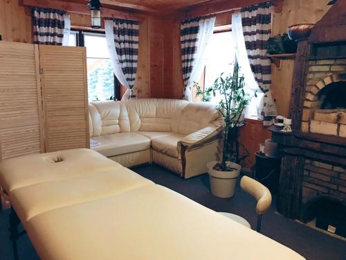 a living room with a white couch and a fireplace at Karpaty Migovo in Migovo