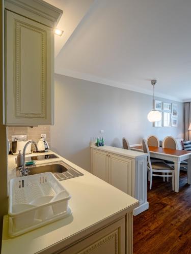 a kitchen with a sink and a table with chairs at Perla Mare Apartamenty in Krynica Morska