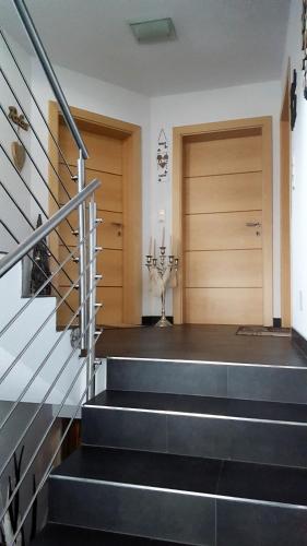a hallway with stairs and a wooden door at Haus am Wald in Neustift im Stubaital