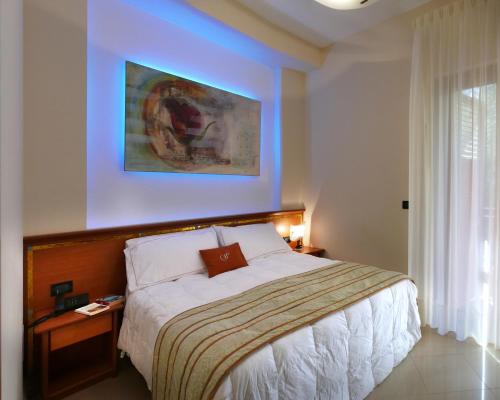 a bedroom with a bed and a painting on the wall at Hotel Residence Piccolo in Parghelia