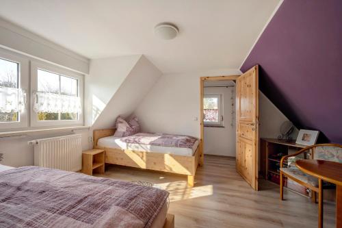a attic bedroom with two beds and purple walls at Ferienhaus Krawulski in Hohnstein