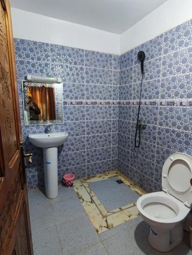 a blue tiled bathroom with a toilet and a sink at imlil in Imlil