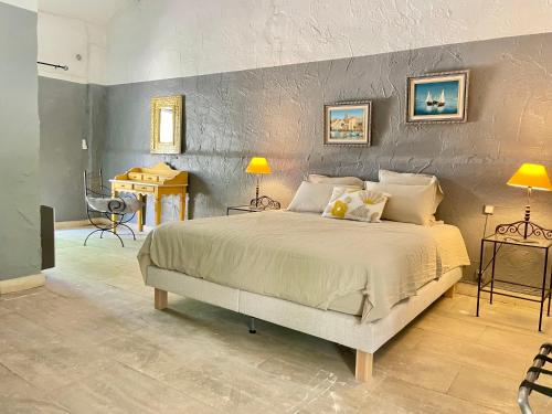 a bedroom with a large bed and a table at Mas des 4 fontaines in Robion en Luberon