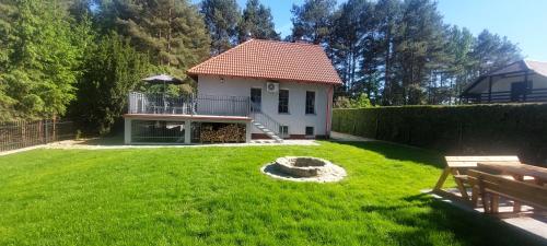 a house with a yard with a fire pit at Apartament AURA - Cichy Zakątek - Kujanki in Kujanki