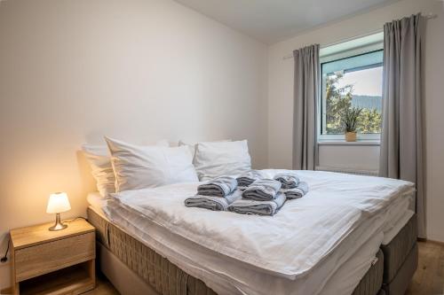 a bed with towels on it in a bedroom with a window at Visit sauna Klinovec in Loučná pod Klínovcem