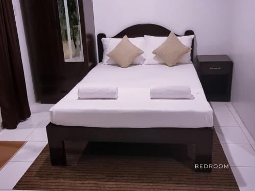 a bed with white sheets and pillows in a room at The Clifftop Home in Esperanza