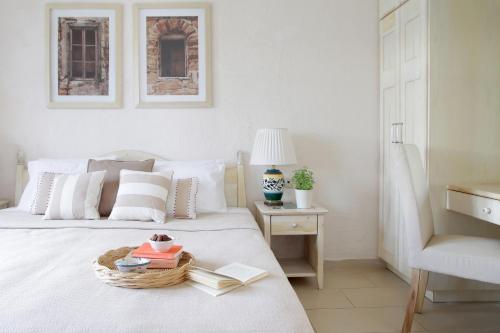 a bedroom with a bed with a basket of books at Skopelos Village Hotel in Skopelos Town