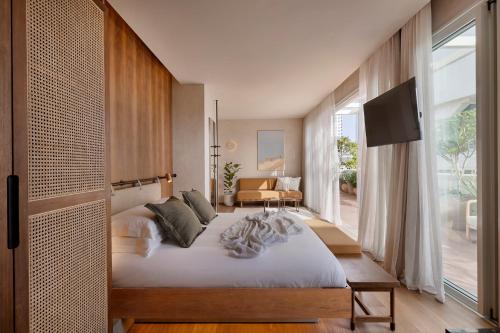 a bedroom with a large bed and a large window at The ABY in Tel Aviv