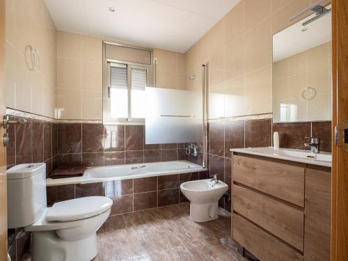 a bathroom with a toilet and a tub and a sink at Villa Joan in Riumar