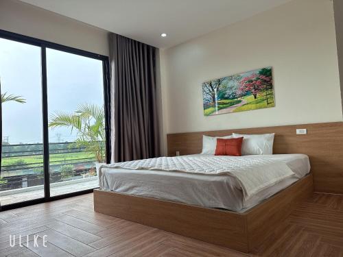 a bedroom with a large bed and a large window at Lala hotel in Phủ Từ Sơn