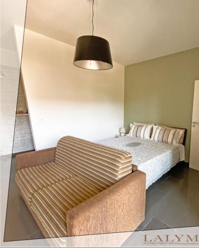 a bedroom with a bed and a couch at Lalym Donnanna Apartment in Rossano Stazione