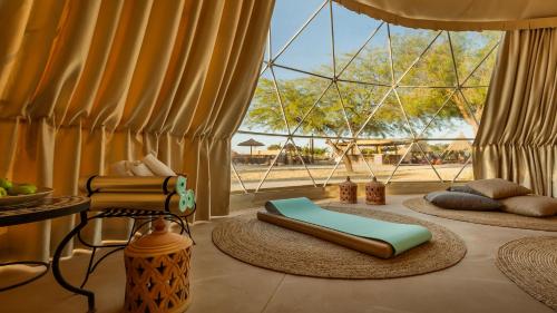 a room with two pillows and a chair and a window at Jacob Mitzpe Ramon in Mitzpe Ramon