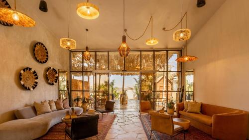 a living room with couches and chairs and large windows at Jacob Mitzpe Ramon in Mitzpe Ramon