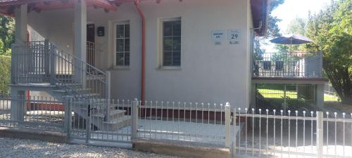 a white picket fence in front of a house at Apartament AURA - Cichy Zakątek - Kujanki in Kujanki