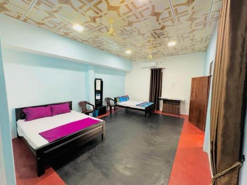 a bedroom with a large bed and a couch at Gulf Villa in Kattankudi