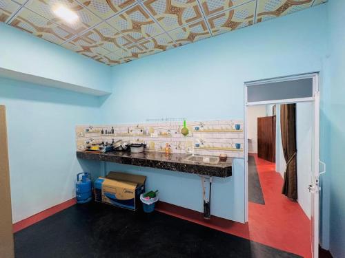 a kitchen with a counter and a blue wall at Gulf Villa in Kattankudi