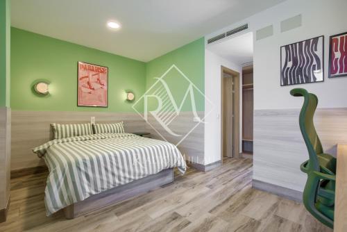 a bedroom with a bed and green walls at Rialto Millau Coliving in Villaviciosa de Odón