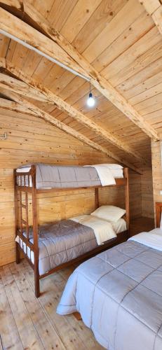 a bedroom with two beds in a wooden attic at Livadhi Guesthouse in Mollʼ e Shoshit