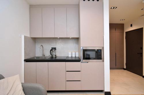 a kitchen with white cabinets and a microwave at Chic city apartment I By Domel Yerevan in Yerevan