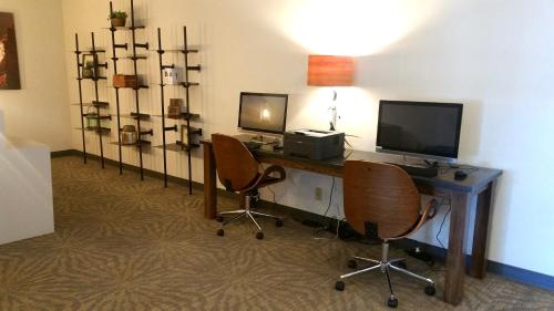 a room with a desk with a computer and two chairs at Ramada by Wyndham Boise in Boise
