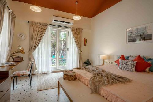 a bedroom with a large bed and a large window at Villa Kefi in Assagao