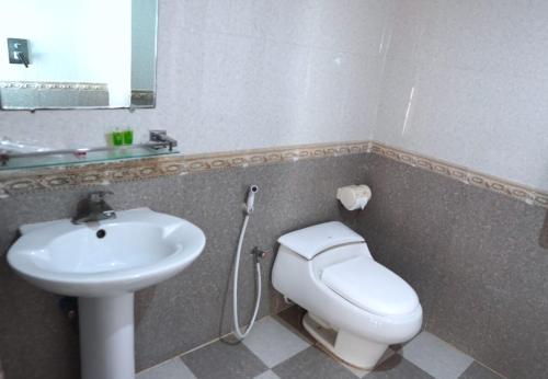 a bathroom with a white toilet and a sink at The Sea Princess Hotel in Cox's Bazar