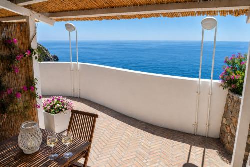 a table and a bath tub on a patio with the ocean at Maridea - Il Paradiso sulla Baia in Ponza
