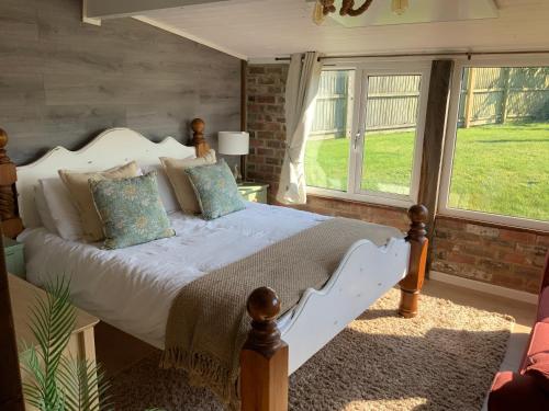 a bedroom with a bed and a large window at fairfeilds cottage Frog Trotters Bottom in Hartpury