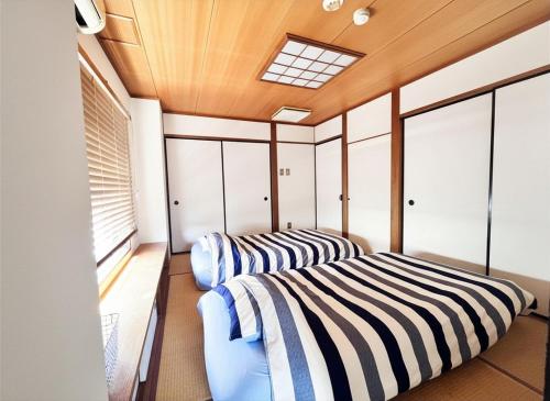 two beds in a room with a window at The Little Kamakura Hotel 鎌倉駅徒歩2分 in Kamakura