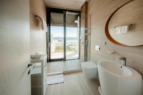 a bathroom with a sink and a toilet and a mirror at Nyota Hotel & Conference Center in Mamaia