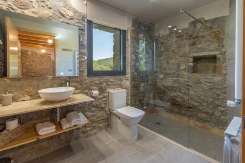 a bathroom with a toilet and a sink and a shower at Mas Ca la Rossa in Girona