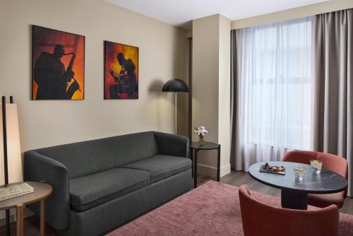a living room with a couch and a table at NH Barcelona Diagonal Poblenou in Barcelona
