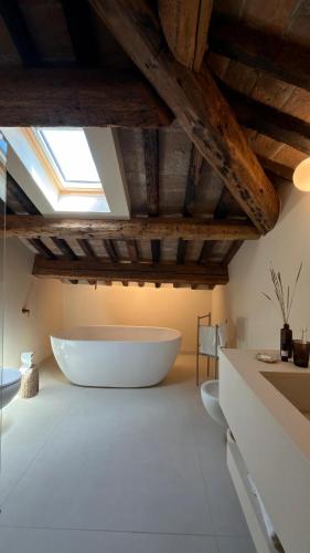 a large white bath tub in a bathroom with a ceiling at Suite Los Arcos in Chioggia