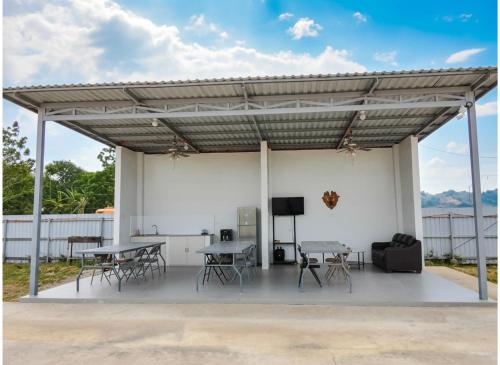 a pavilion with tables and chairs and a television at Villa Cedes in Lasam