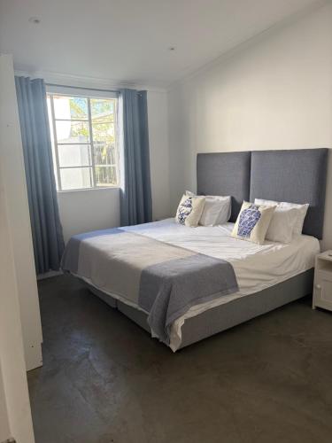 a large bed in a bedroom with a window at Bayerley in Plettenberg Bay