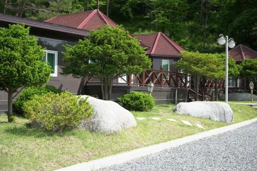 a house with two large rocks in the yard at Yeongwol Jangsan Condo in Yeongwol