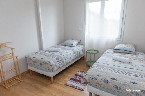 two beds in a room with a window at Le balcon de Compostelle in Espaly-Saint-Marcel